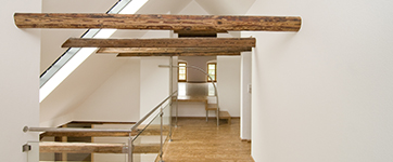 White hallway with an apex sealing and exposed wooden beams
