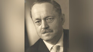 An old photo depicting a middle aged man with a moustache wearing a suit