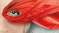 A womans eye surrounded by red petals